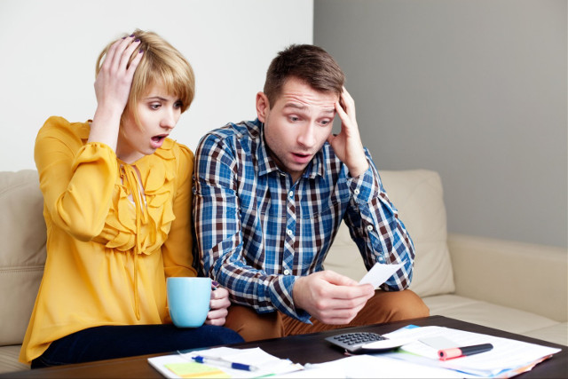 Shocked couple looking at bills